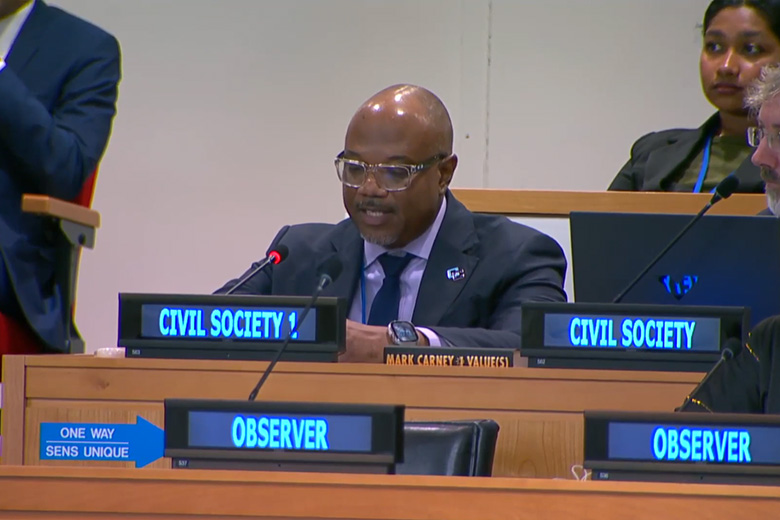Kenneth Connell sitting at a desk speaking at the United Nations