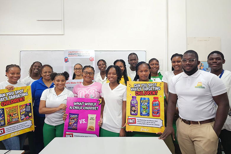Campaigners holding educational posters about child-targeted food marketing, standing around a white table