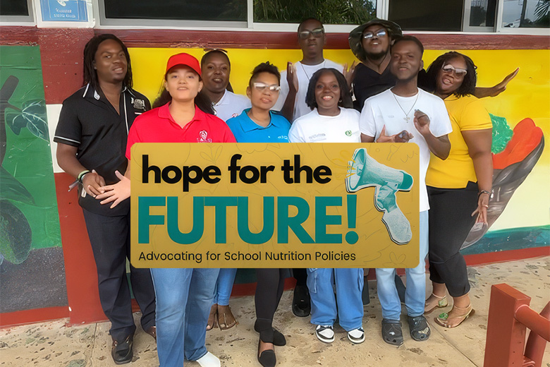 Group of advocates standing outdoors beneath organisation logos with a Hope for the Future banner promoting school nutrition policies