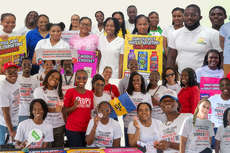 Healthy Caribbean Coalition activists gather, holding signs for a child health campaign. Top text reads: 'HOPE FOR THE FUTURE 3.0'