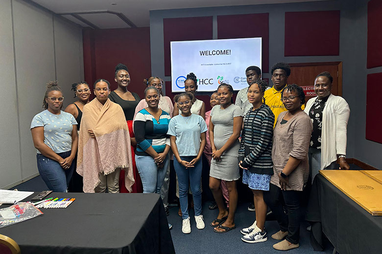 Diverse group of participants smiling together in a conference room, posing during a workshop